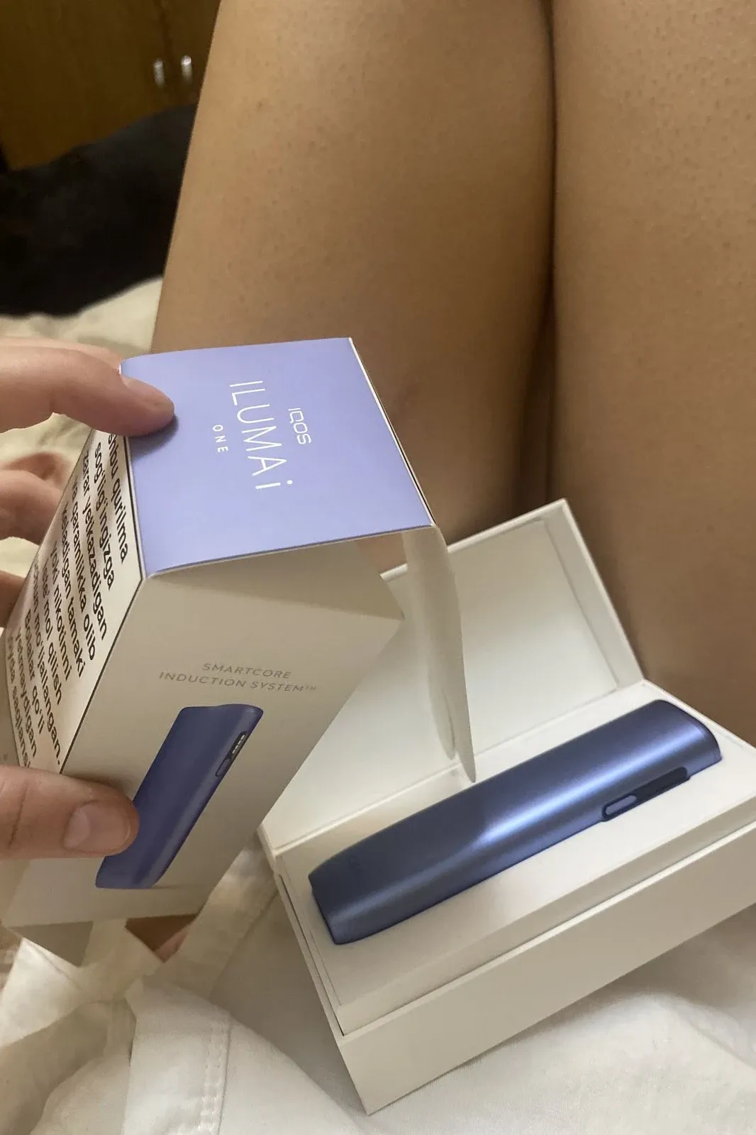 A customer opens the box of a lilac ILUMA i ONE